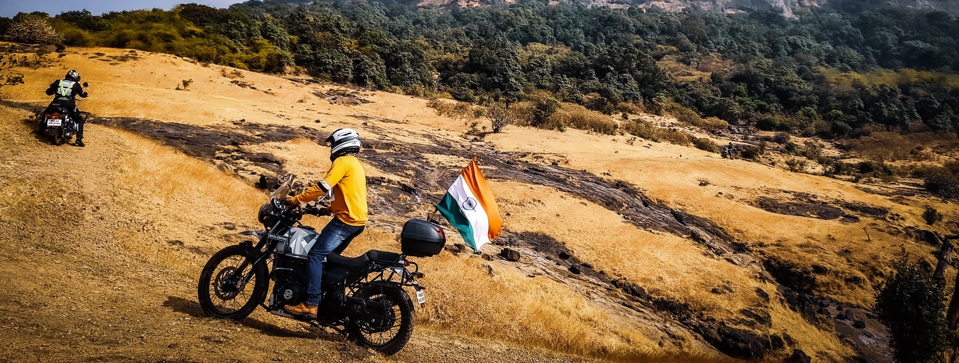 Adventure motorcycle riders crossing a mountain pass at sunrise